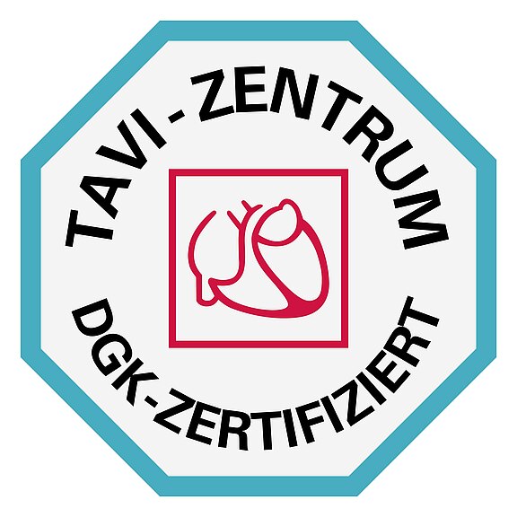 Achtkantiges Siegel mit Herzsymbol: Aufschrift „TAVI-ZENTRUM“ und „DGK-ZERTIFIZIERT“. Kennzeichnet ein von der Deutschen Gesellschaft für Kardiologie zertifiziertes TAVI‑Zentrum.