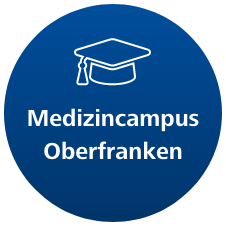 Medizincampus Oberfranken Kreisförmiges Logo des Medizincampus Oberfranken mit einem akademischen Hut-Symbol und dem Text „Medizincampus Oberfranken“ in weißer Schrift auf blauem Hintergrund.